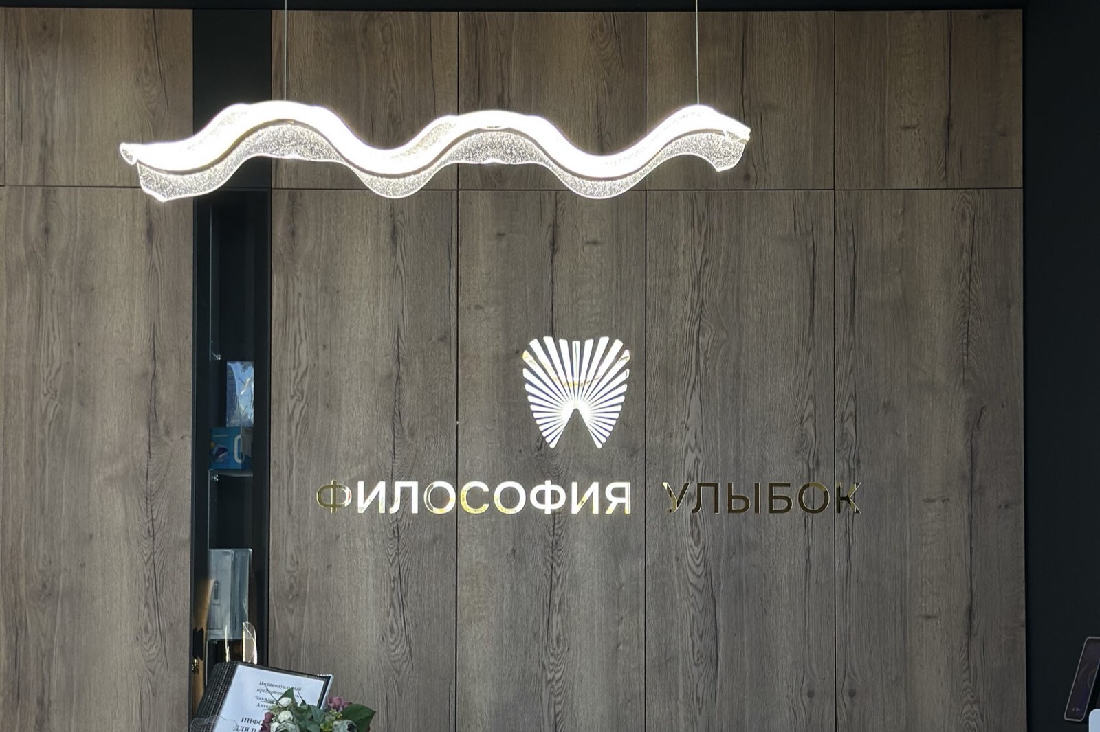 Ресепшн клиники с фирменным логотипом «Философия Улыбок»
